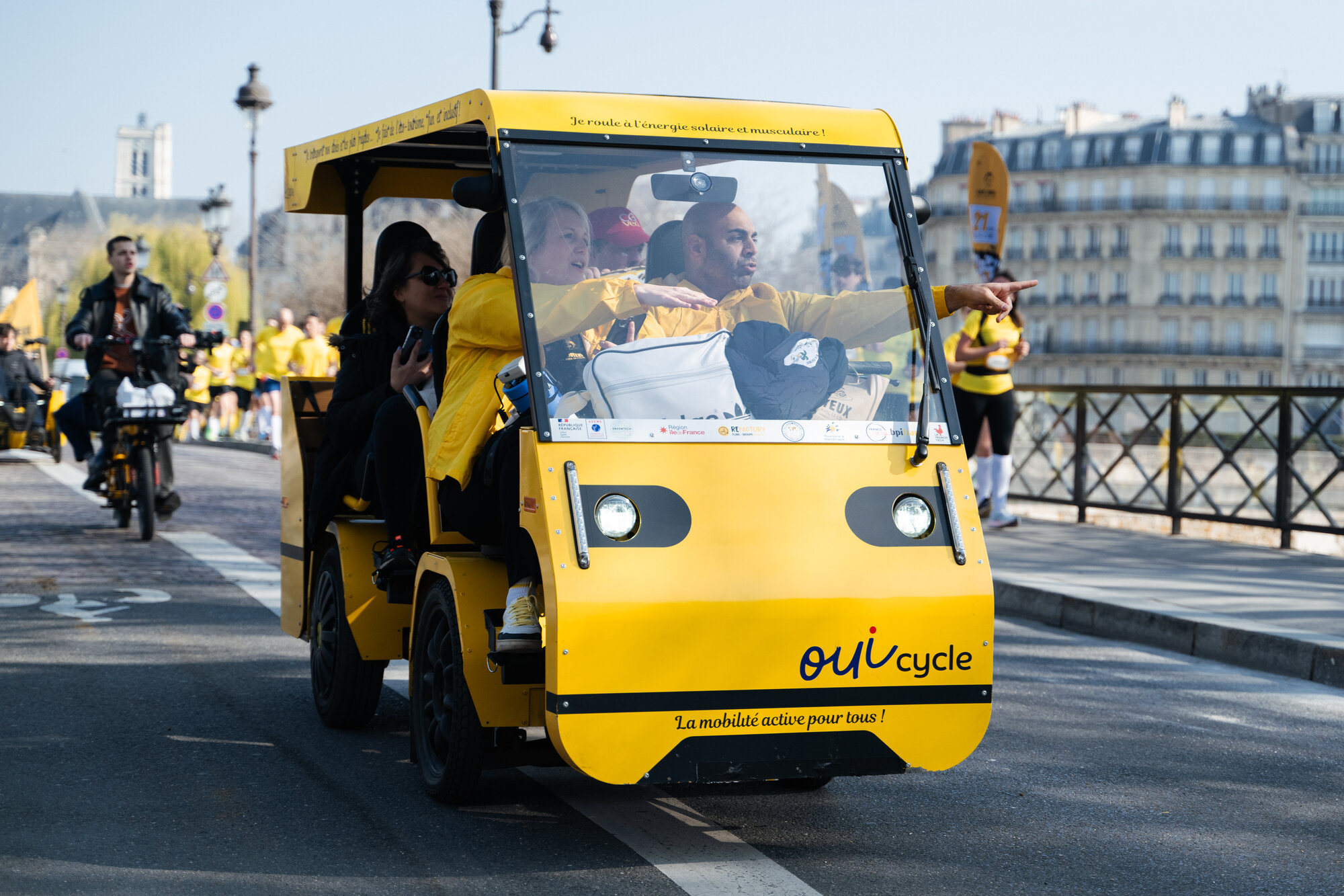 Le OuiCycle en balade dans la ville, passagers souriants.